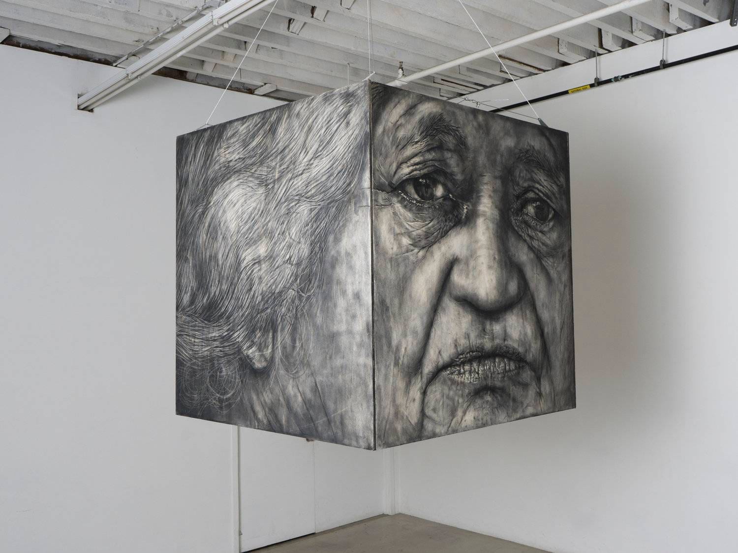 a cube hanging with a charcoal portrait of an older person