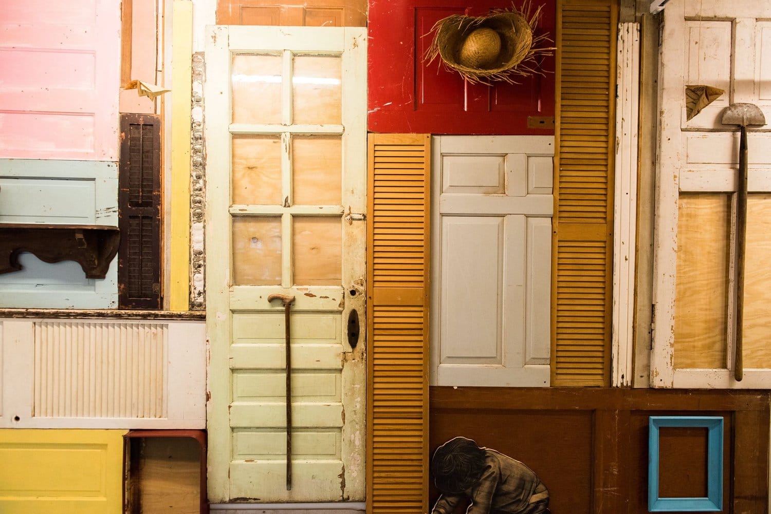 an in installation of various colored doors and wooden structures