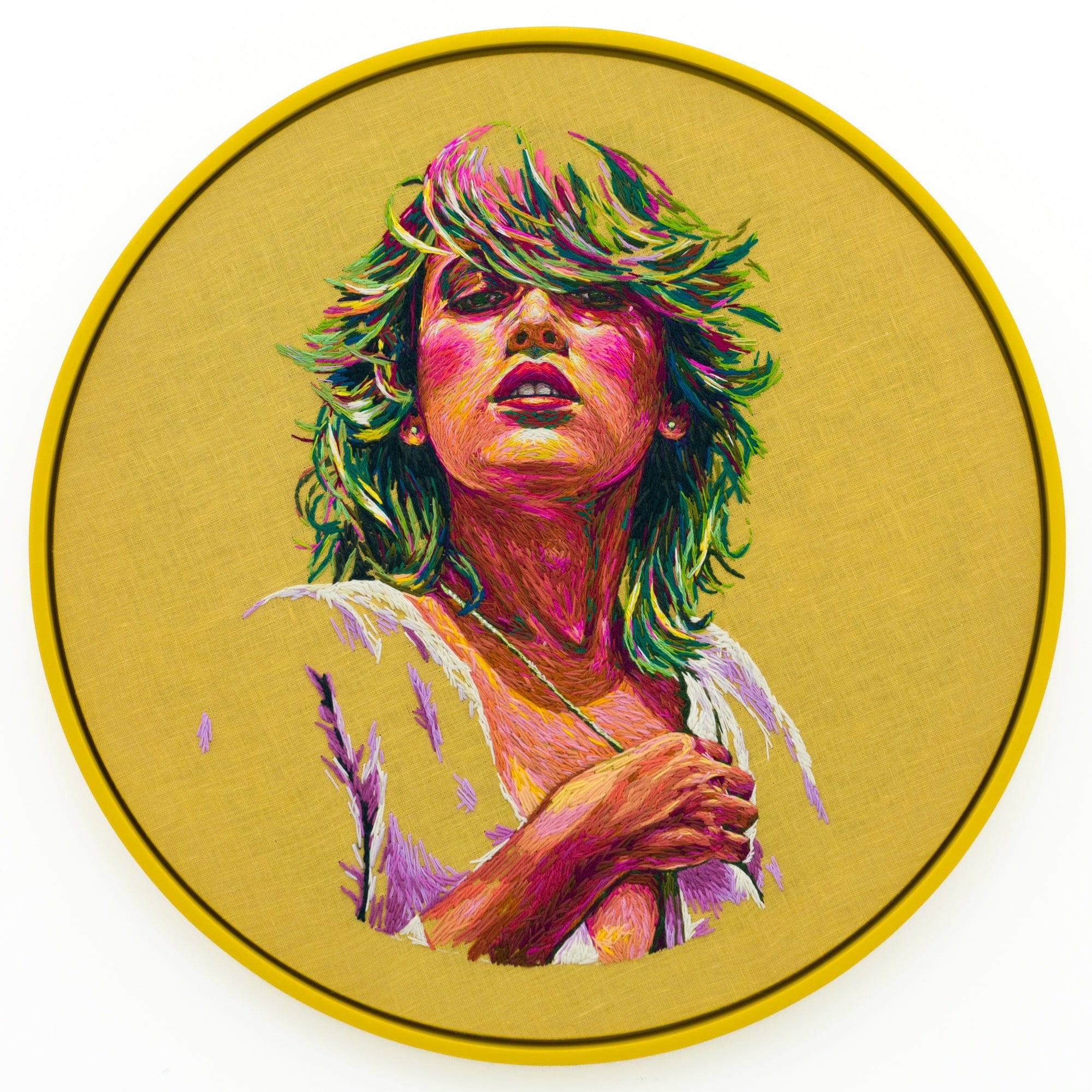 a round crewel embroidery composition by Danielle Clough of a woman with 1970s-era hair on a yellow background