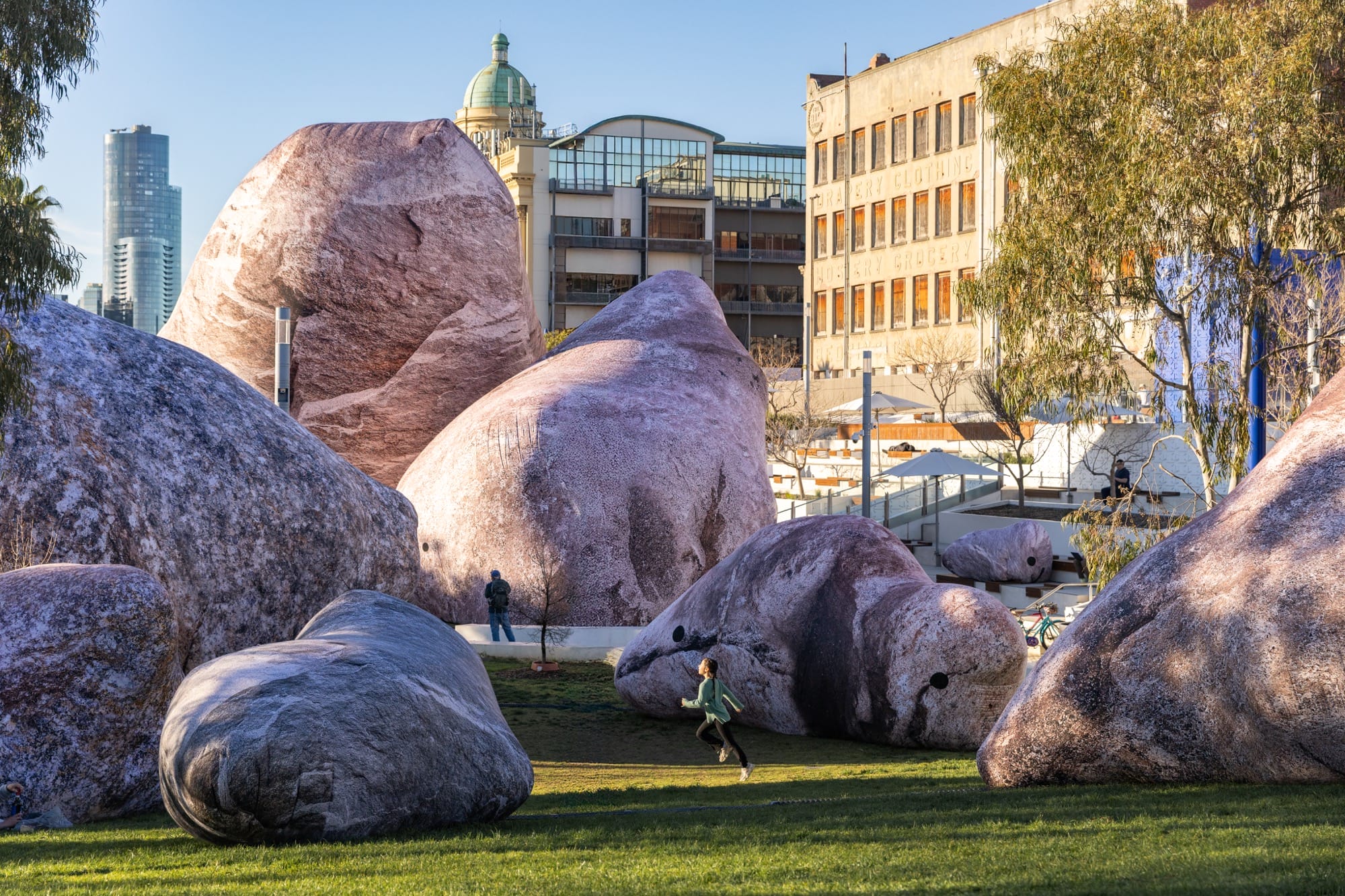 a child runs among massive inflatable rocks