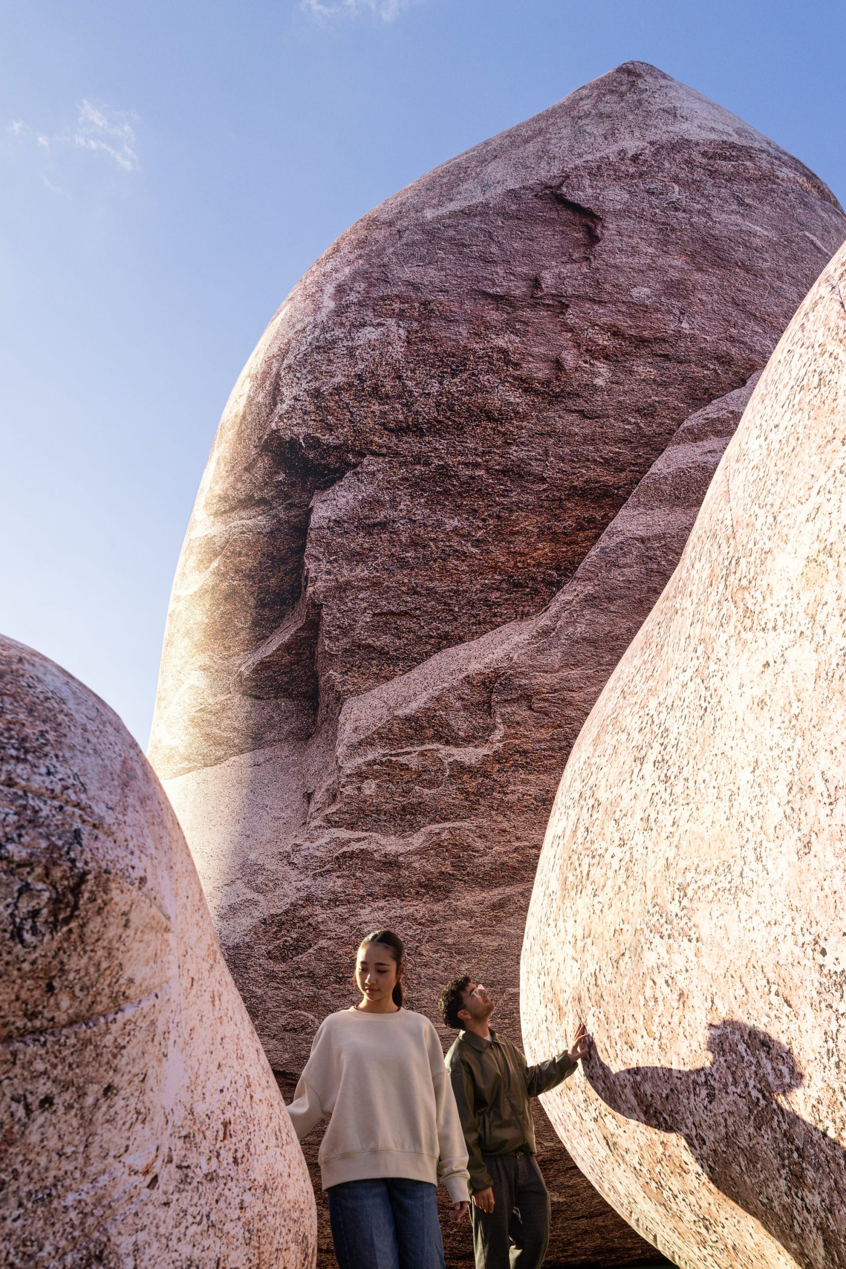 people stand between massive inflatable rocks