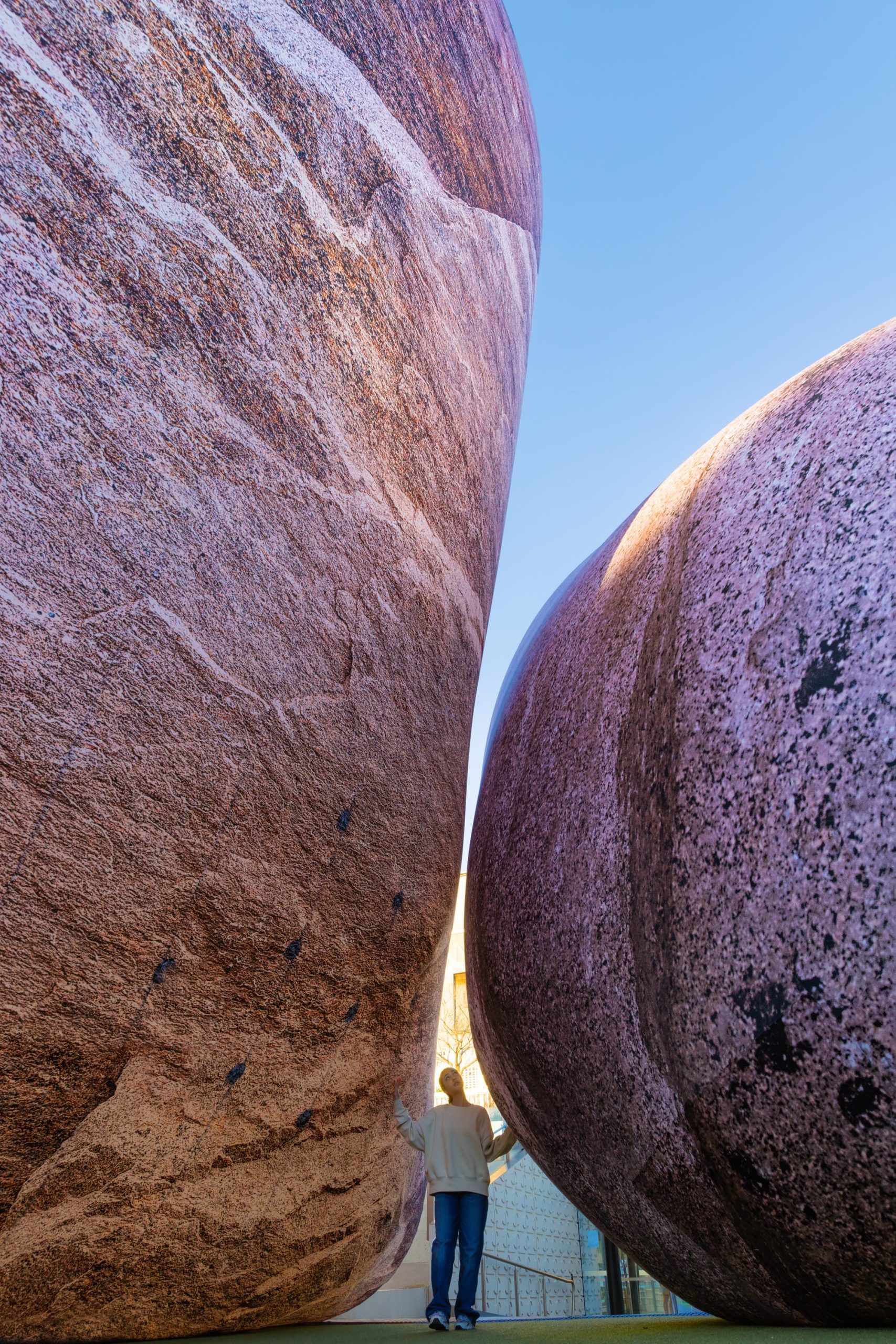 people stand between two massive inflatable rocks