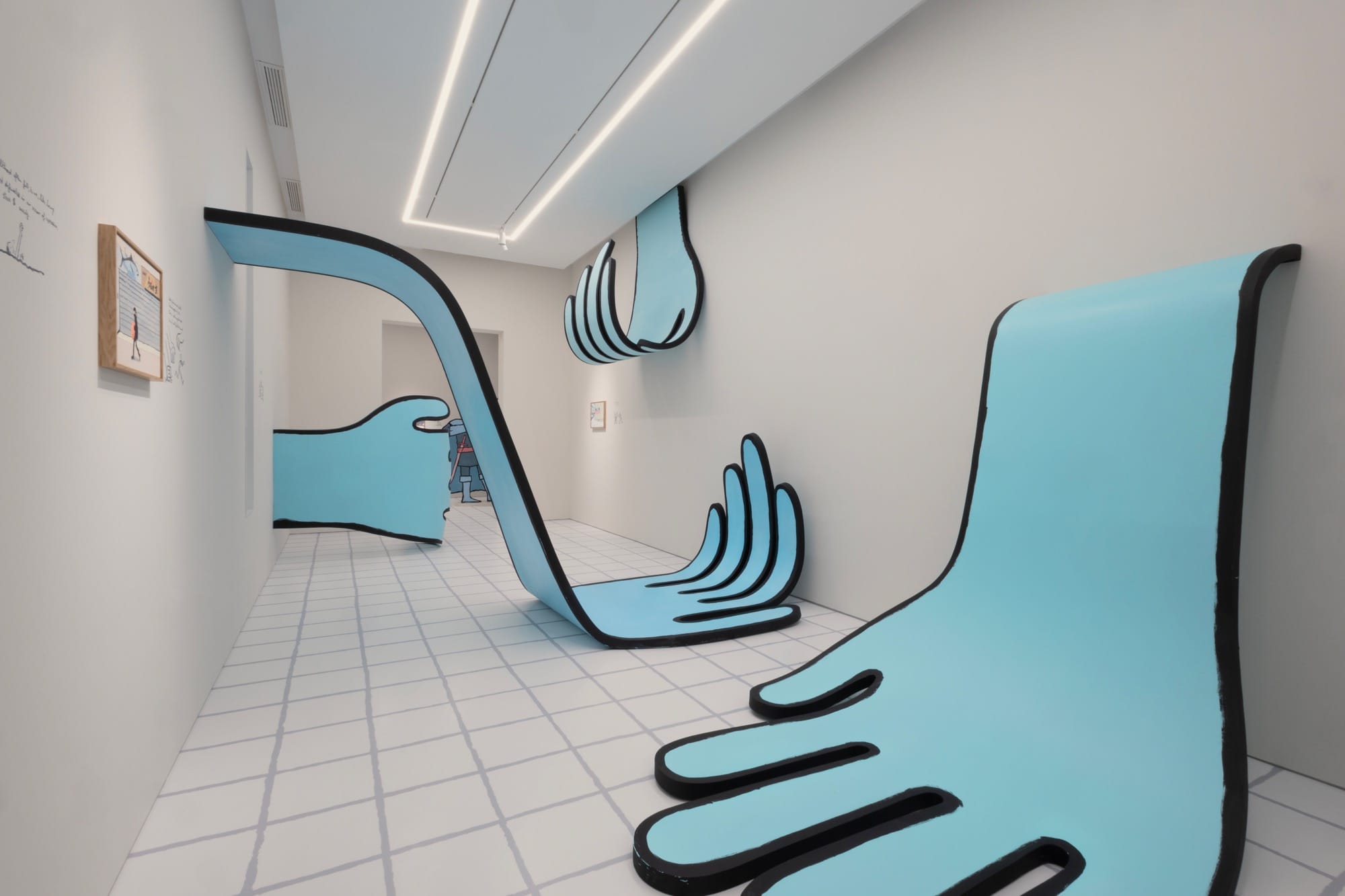 large blue drawn hands flop and extend in a narrow hallway