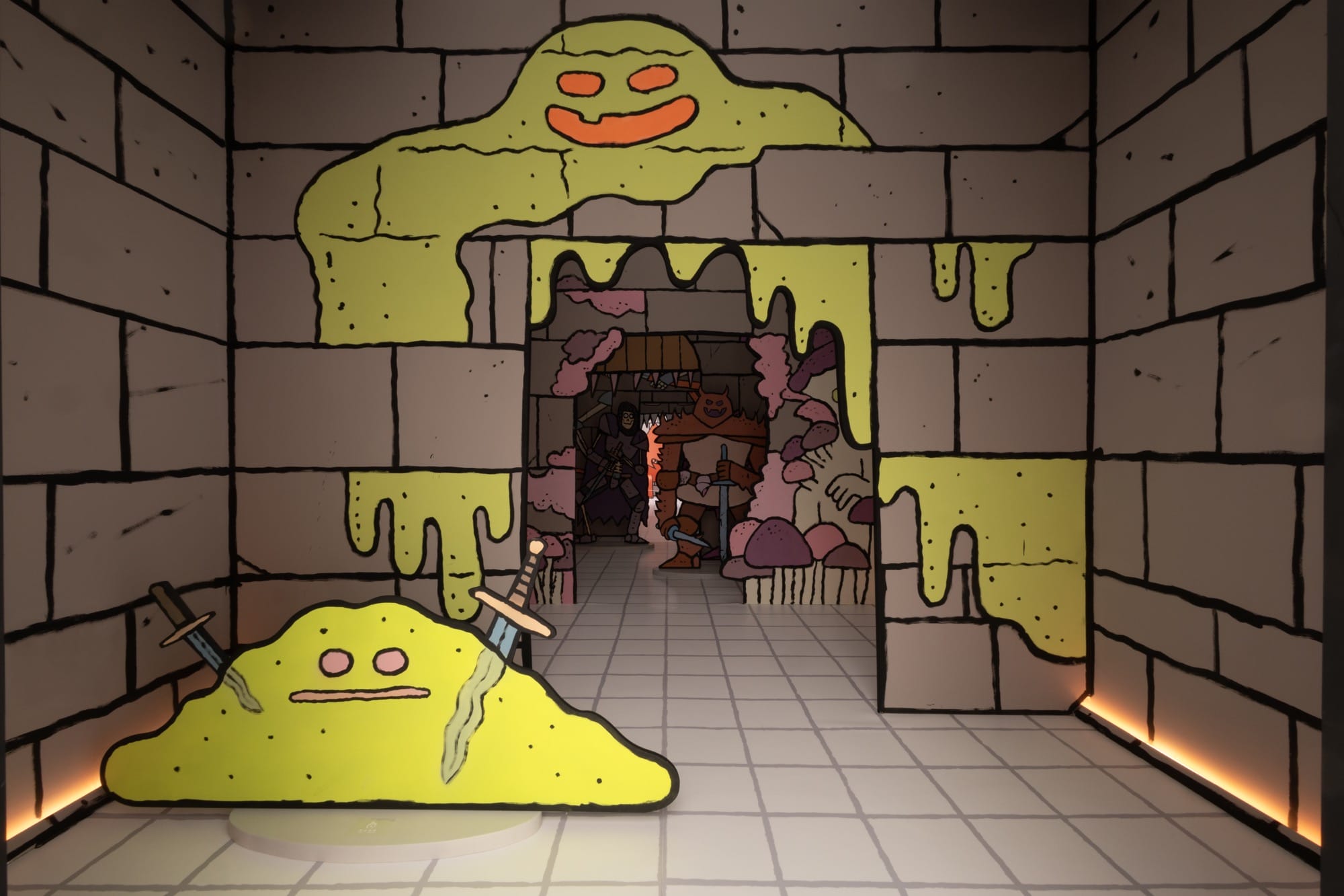 a green monster drips on the drawn walls of a concrete-like room with a central passageway