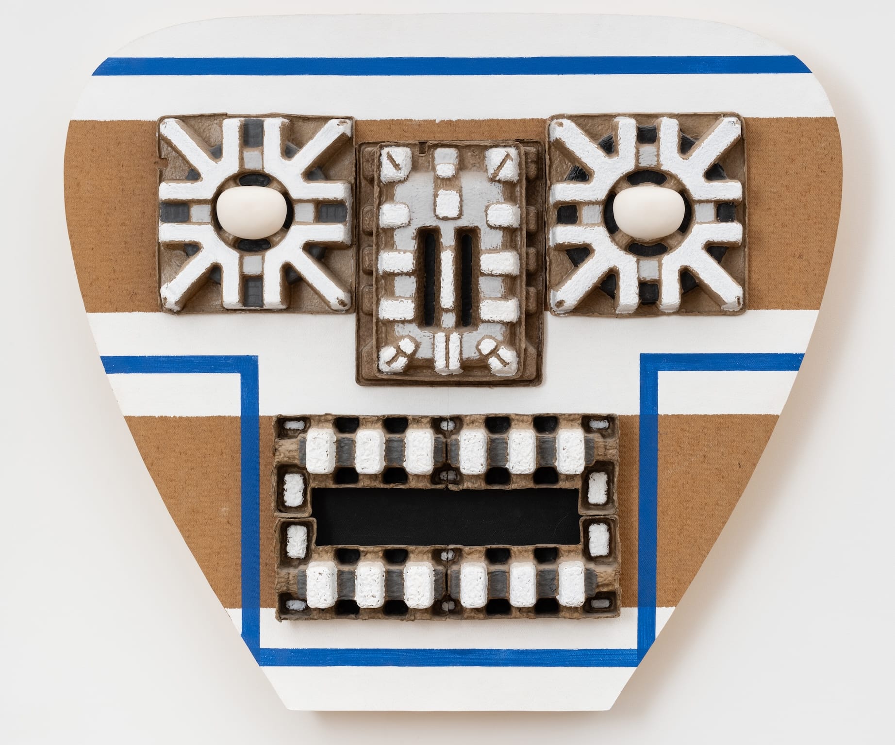 an abstract wall sculpture by Steve Kesiter of a blue and white Mesoamerican deity
