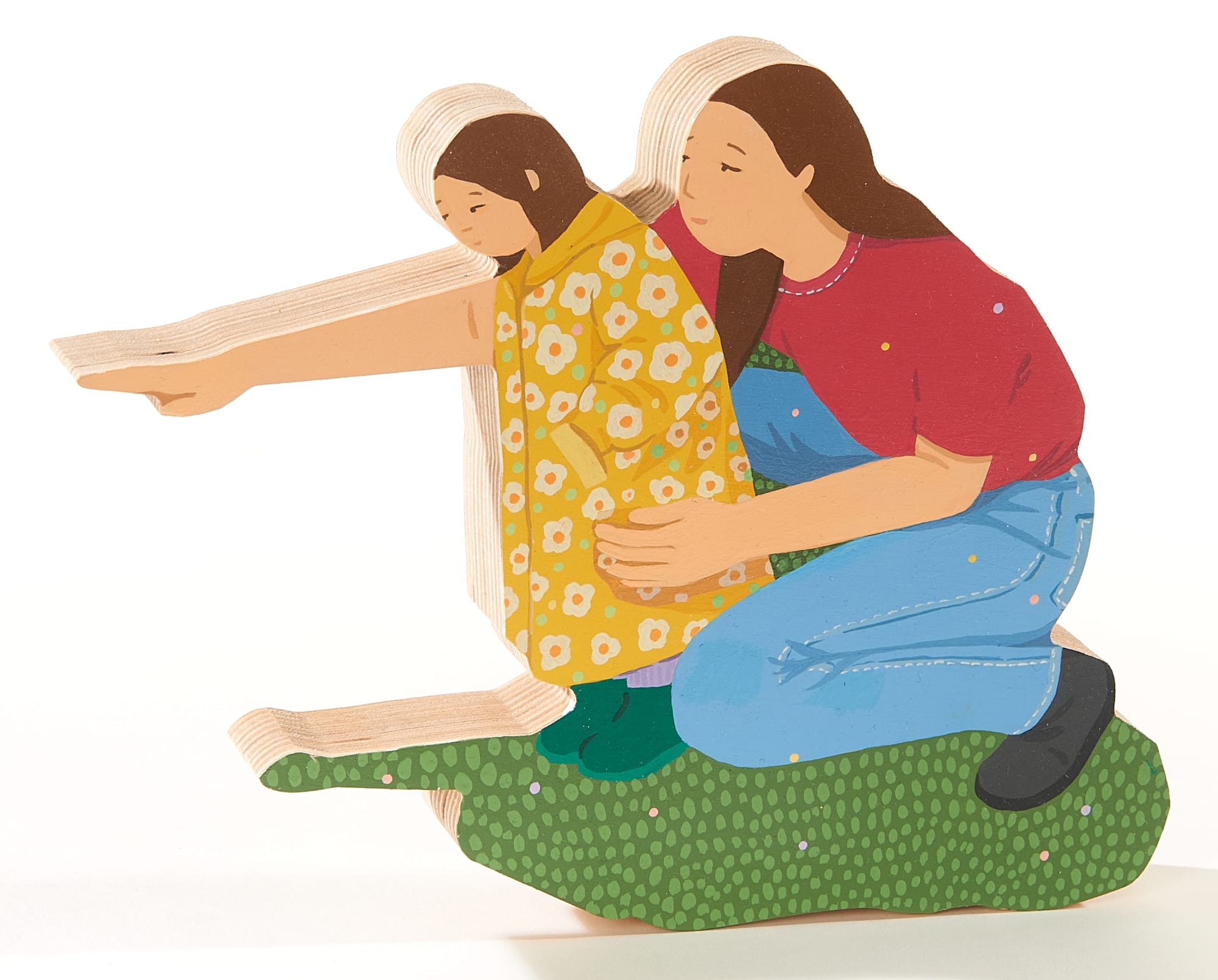 a wood sculpture of a mother and child who is pointing