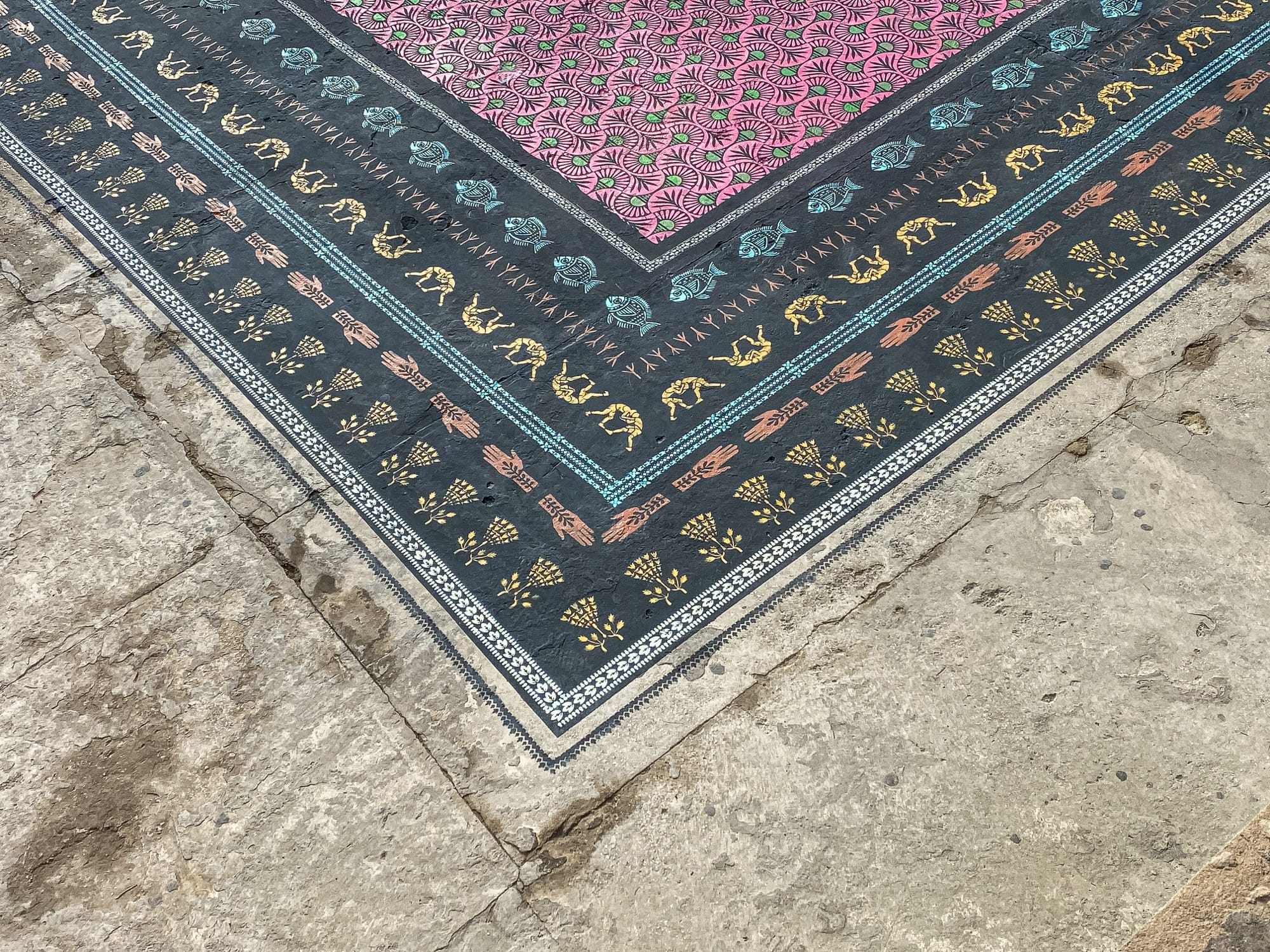 a corner detail of a spray-painted ornate carpet on a rooftop in Dakar