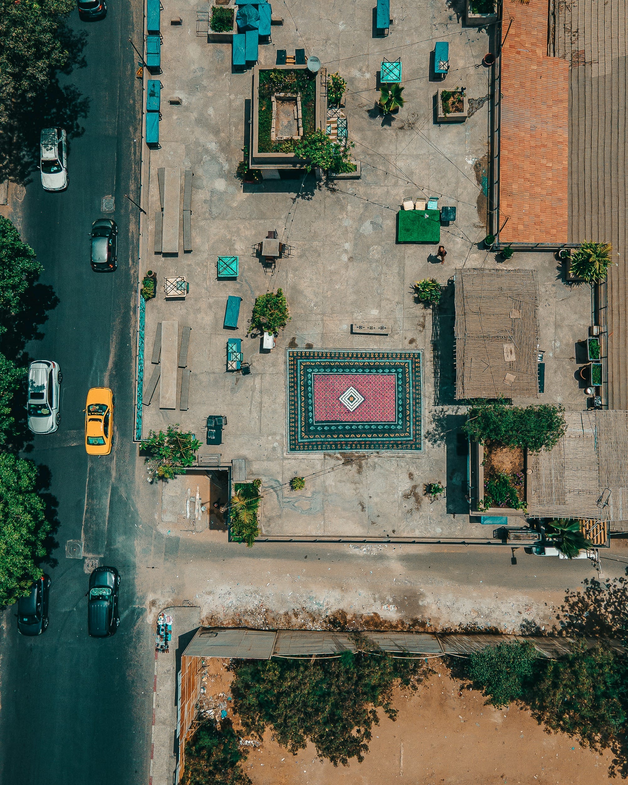 a drone shot of a spray-painted ornate carpet on a rooftop in Dakar