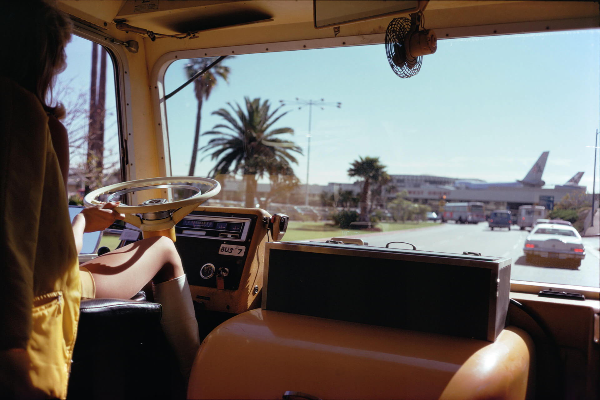 A photo by Joel Meyerowitz of a woman driving a bus at Los Angeles Airport