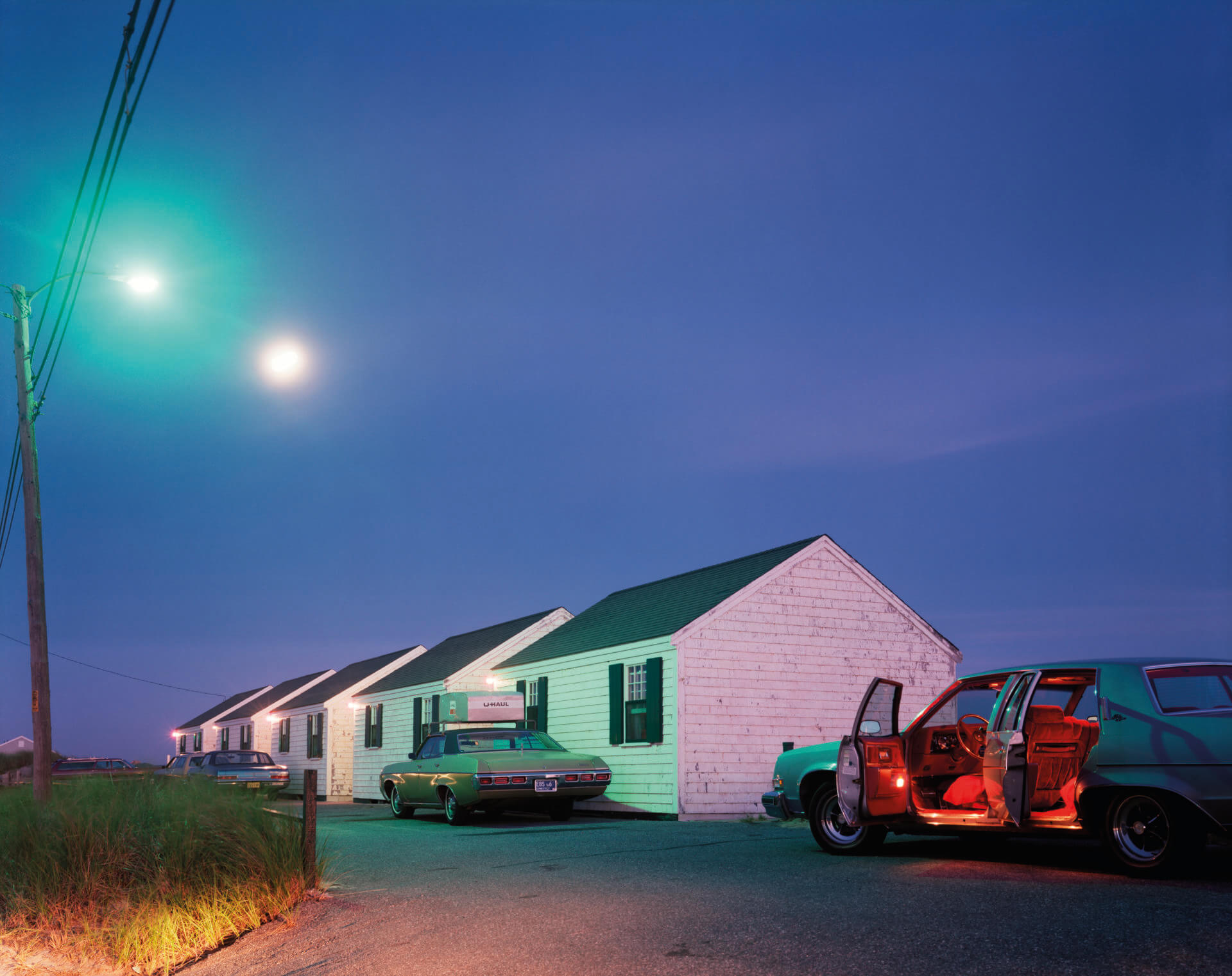 a photo of a row of white houses at night by Joel Meyerowitz