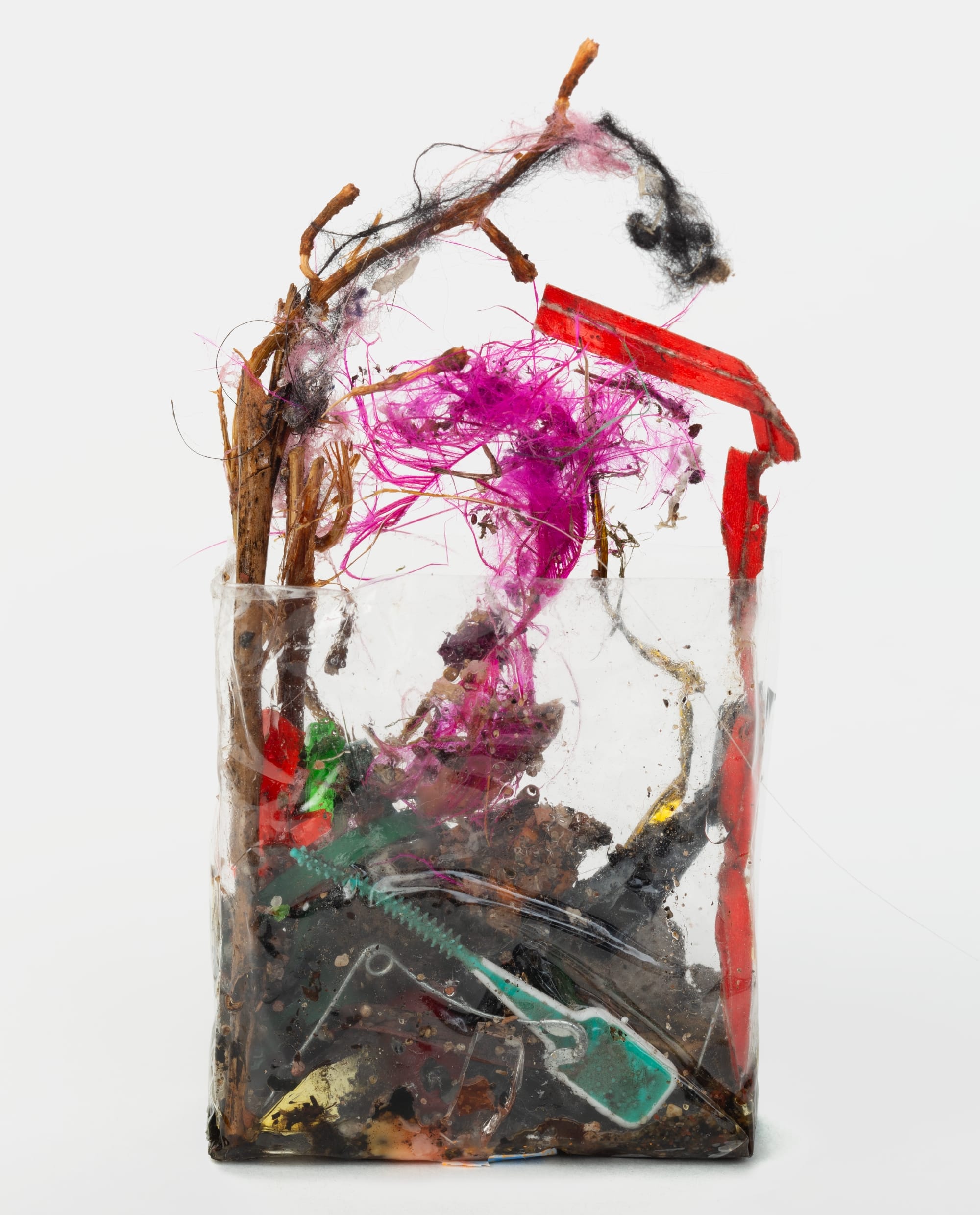 wire, plastic strings, wrappers, and other refuse in a clear plastic cellophane wrapper