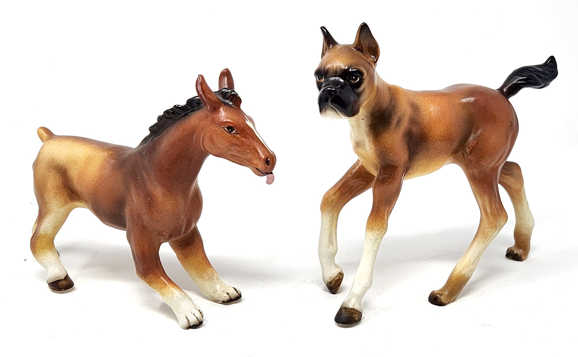 two figurines by Debra Broz, one has a horse head and dog bottom, while the other has a dog head and horse bottom