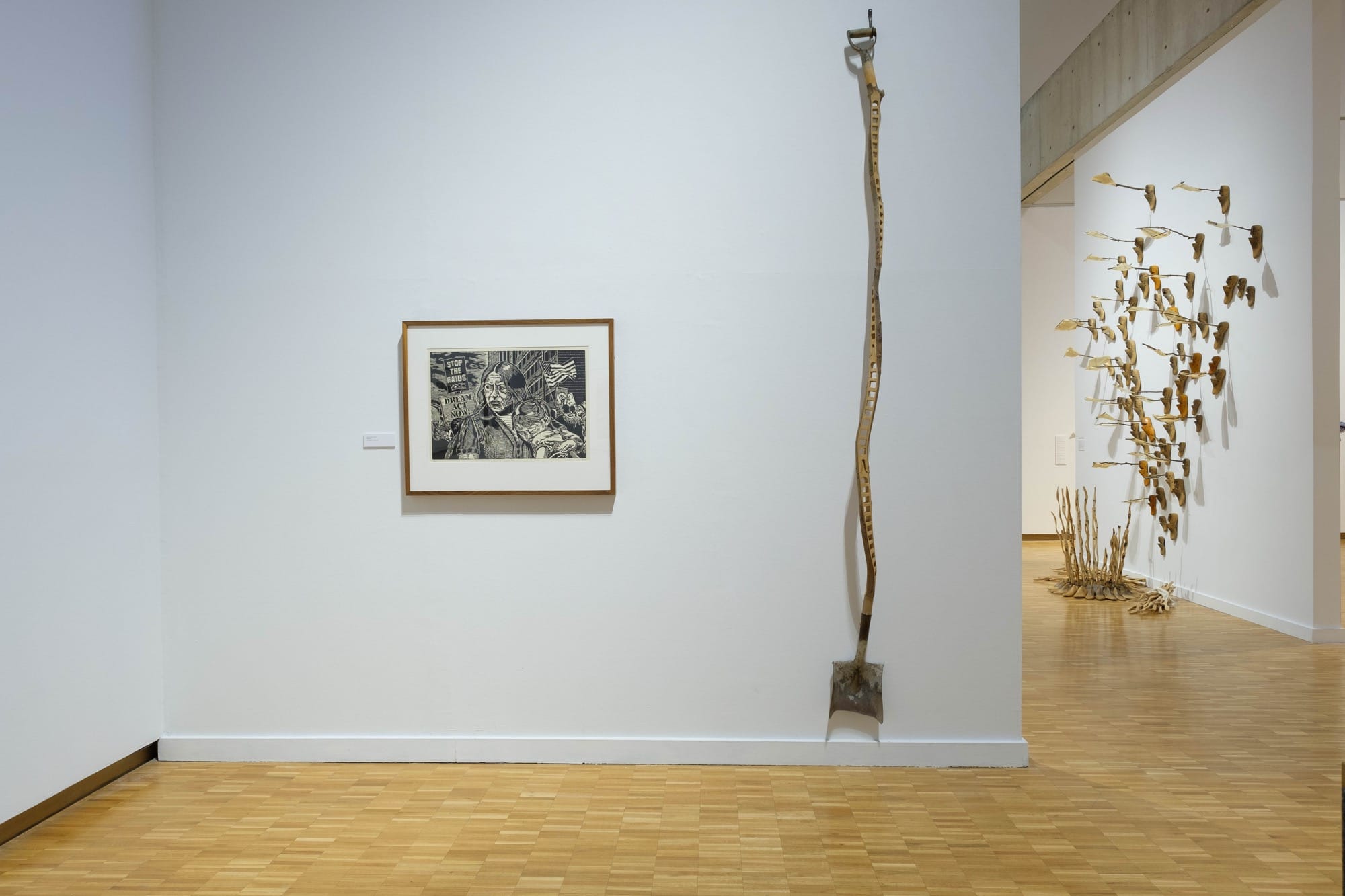 a woodcut portrait and shovel sculpture by Raoul Deal in a gallery at the Haggerty Museum of Art