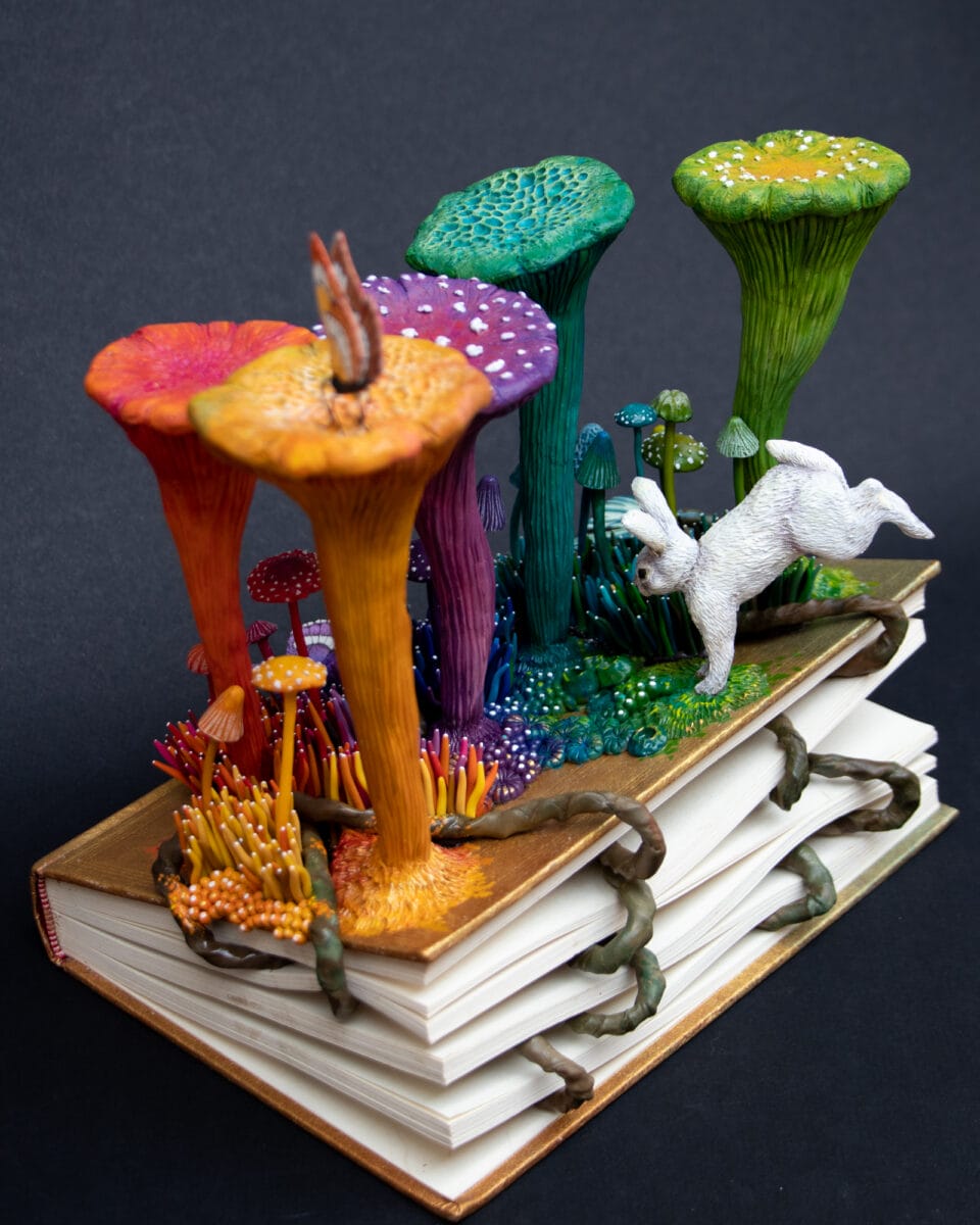a sculpture by Stéphanie Kilgast of colorful mushrooms growing out of an old book