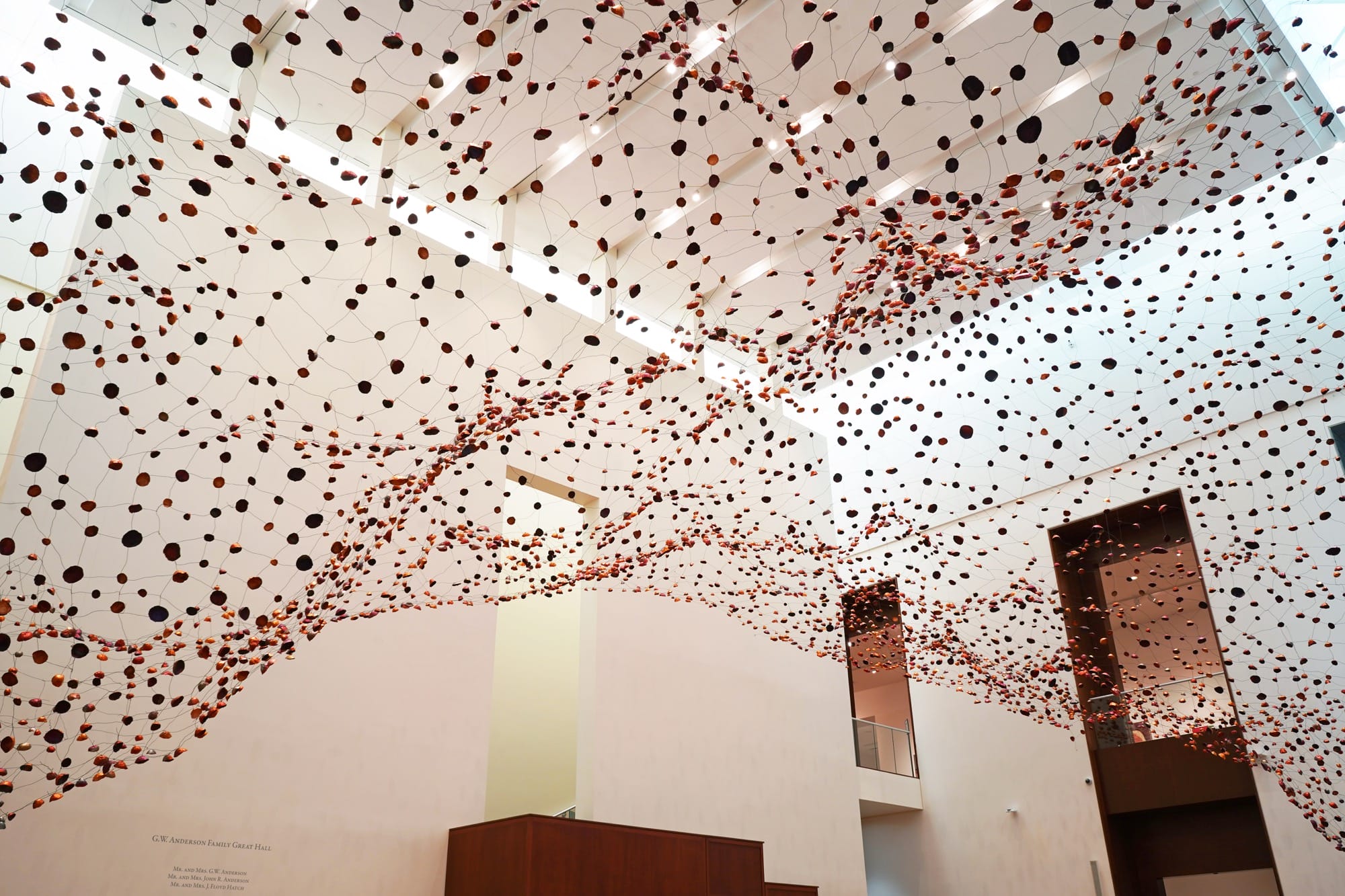 an installation view from below of a room-size installation by Yasuaki Onishi made of hundreds of copper forms connected by wire