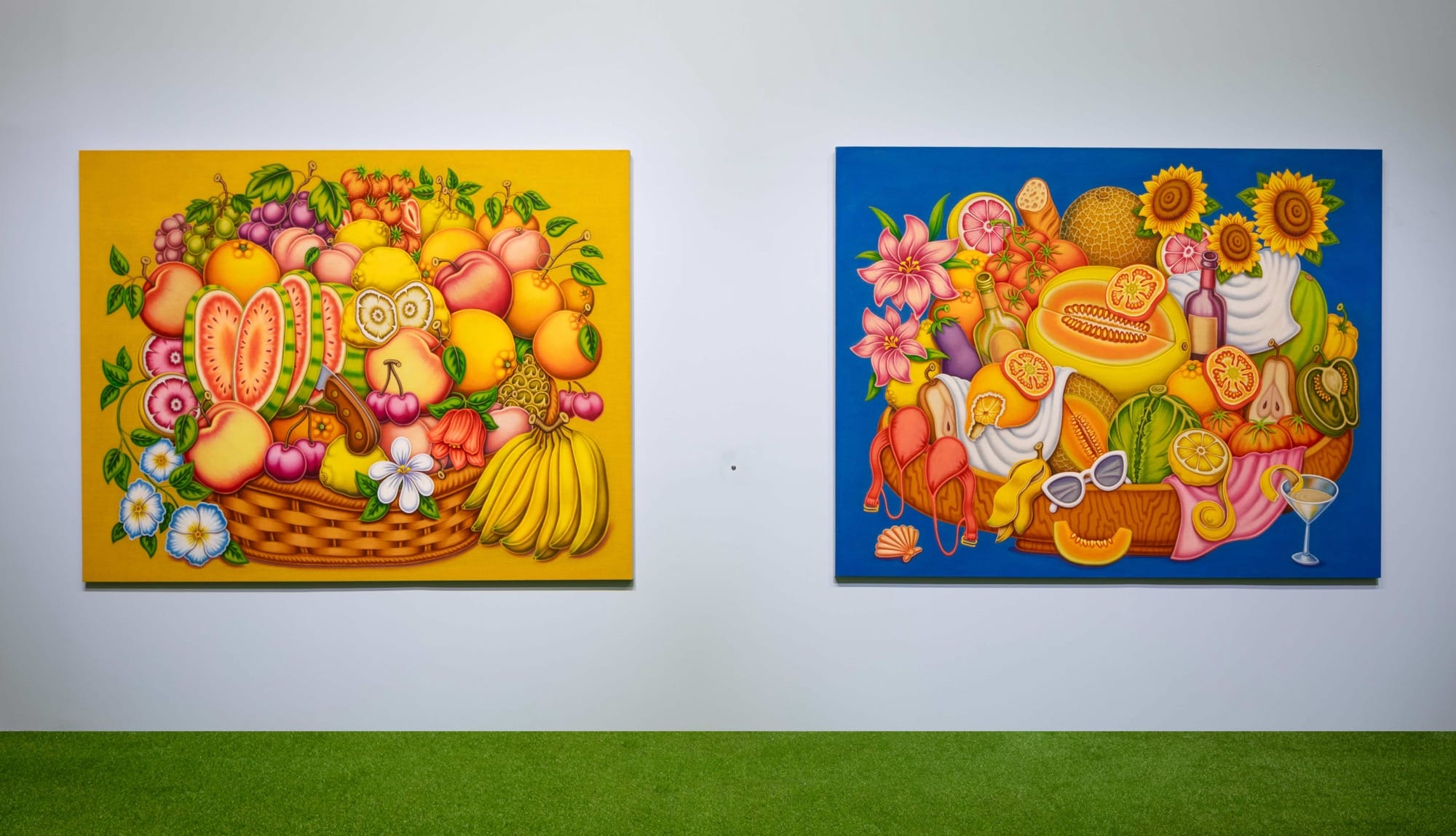two paintings by Pedro Pedro of numerous fruits and treats, installed on a white wall