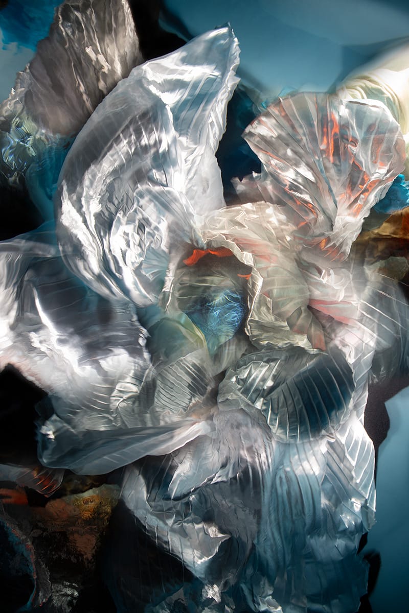 an underwater photograph by Christy Lee Rogers of figures enveloped in billowing fabric