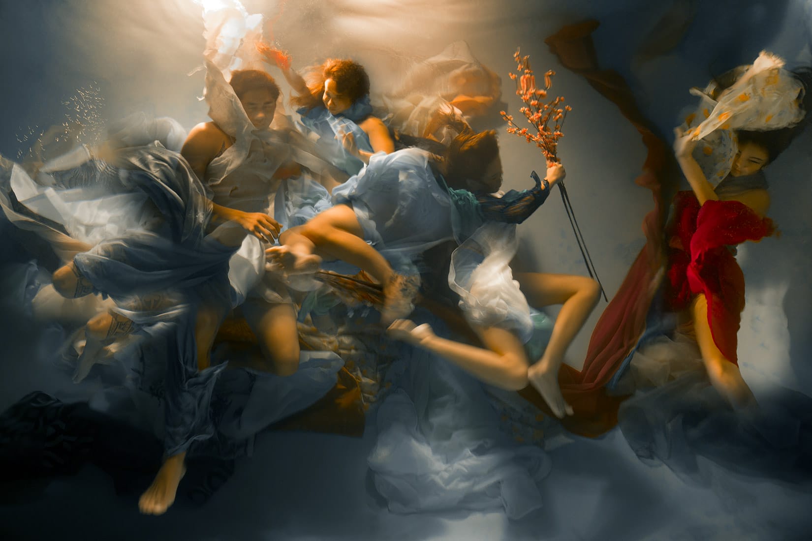 an underwater photograph by Christy Lee Rogers of figures enveloped in billowing fabric