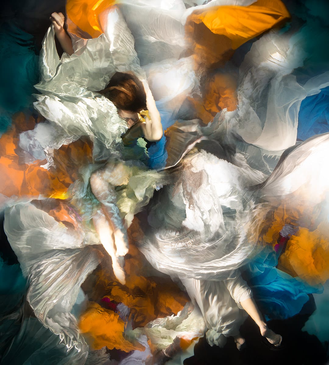 an underwater photograph by Christy Lee Rogers of figures enveloped in billowing fabric