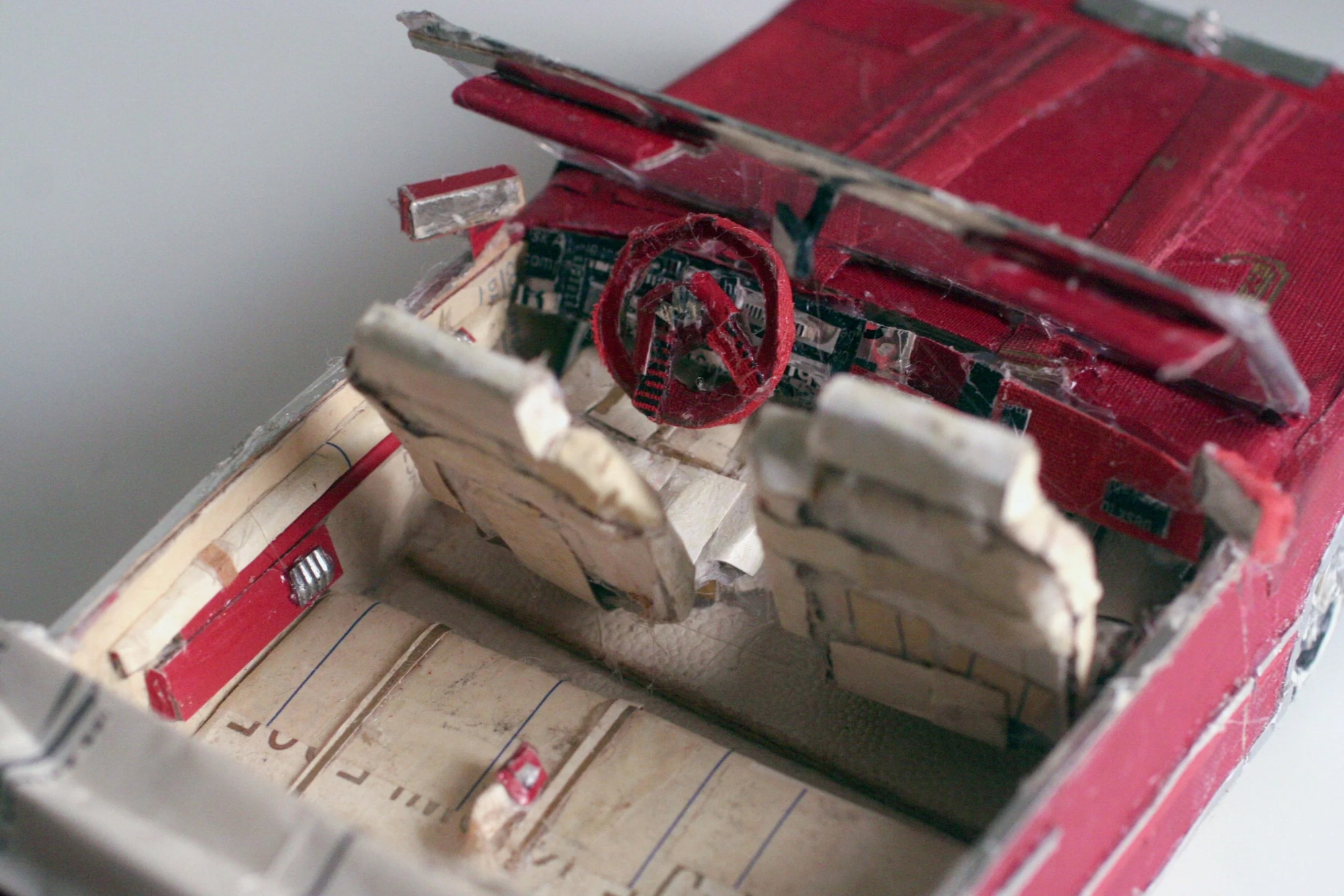 a detail of a red car made from found scraps by Lydia Ricci