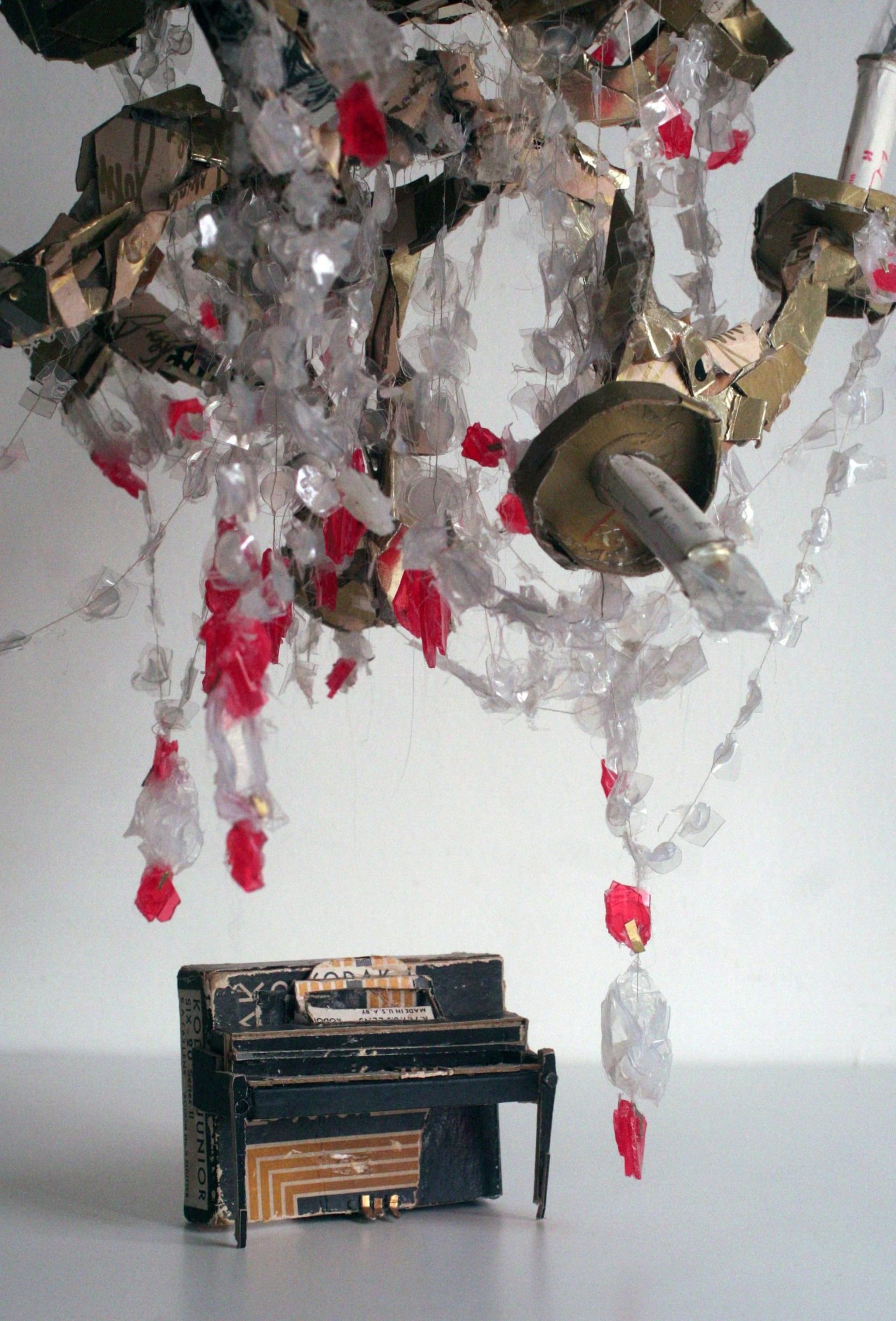 a piano and chandelier made from found scraps by Lydia Ricci